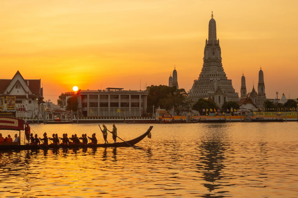 Pontos turísticos de Bangkok: Wat Arun ao pôr do sol com procissão de barcos no rio Chao Phraya
