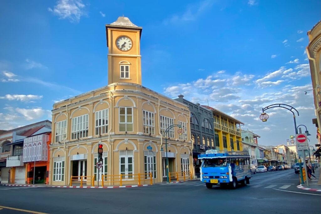 Edifício histórico com torre do relógio em estilo sino-português no centro de Phuket Town, com casarões coloridos ao fundo