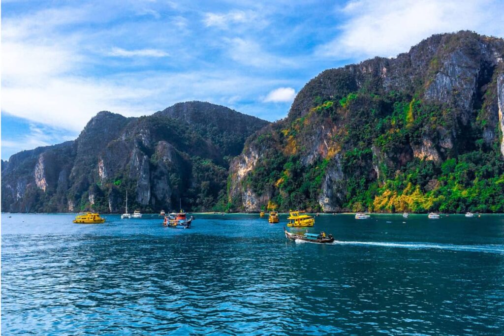 Barcos navegando entre os penhascos de calcário das Ilhas Phi Phi, Tailândia